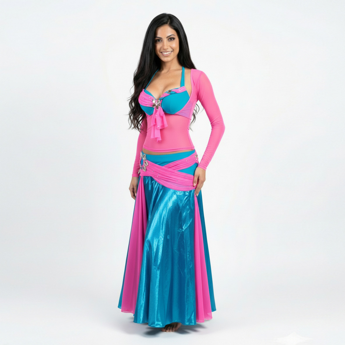 traje danza arabe falda en satin turquesa con capas de tulle fucsia en un diseño circular. Lleva un brasier en Lycra Dupont turquesa, con decoraciones en cristales y en malla tulle fucsia. Además una camiseta que tapa los brazos y el vientre en malla tulle fucsia.